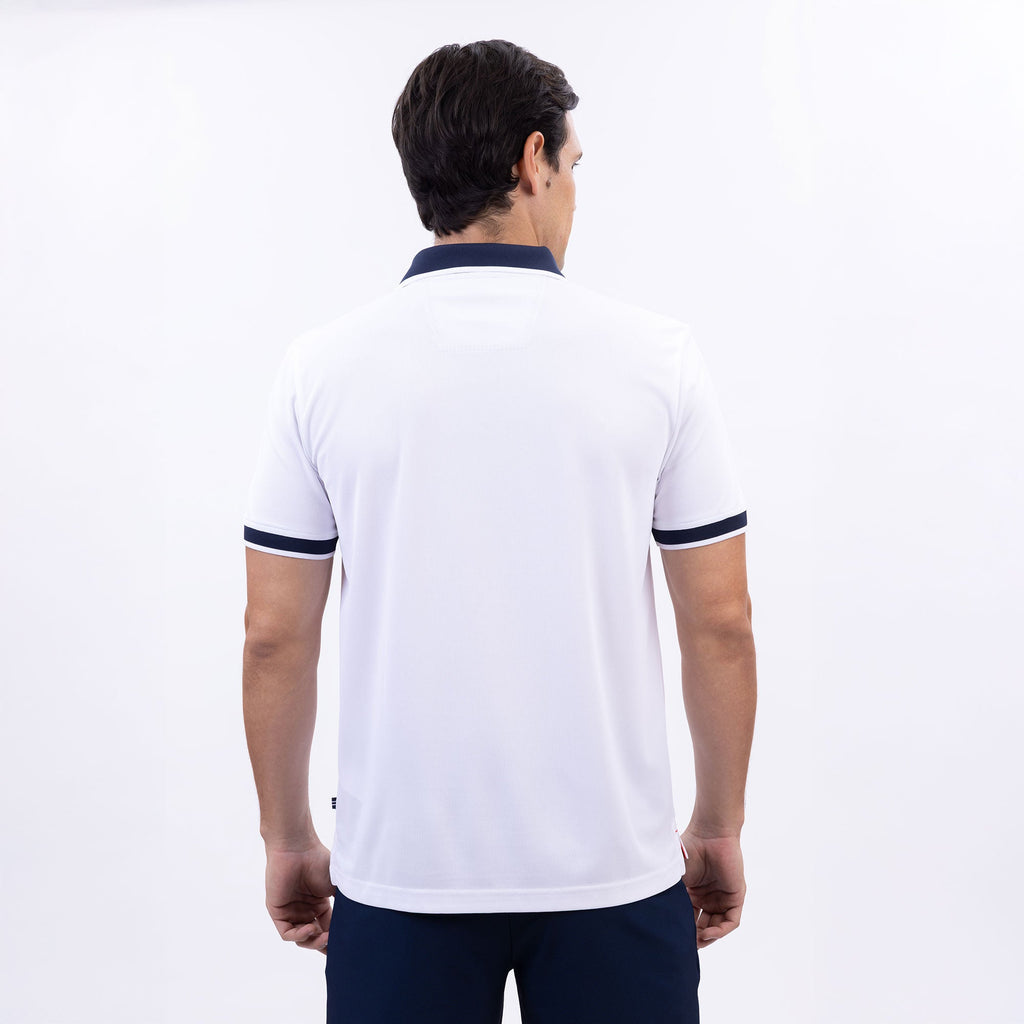 Hombre usando polo blanca con cierre, cuello azul marino y logo Nautica, hecha con poliéster reciclado