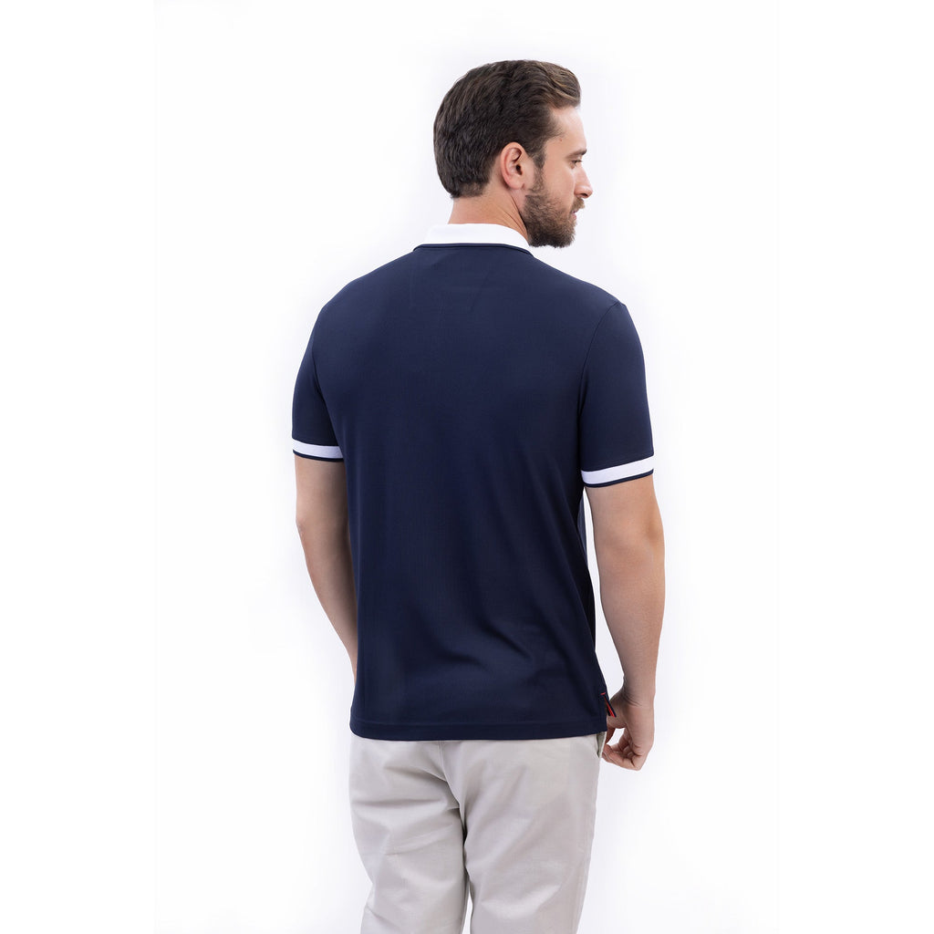 Hombre usando polo azul marino con cierre, cuello blanco y logo Nautica, hecha con poliéster reciclado